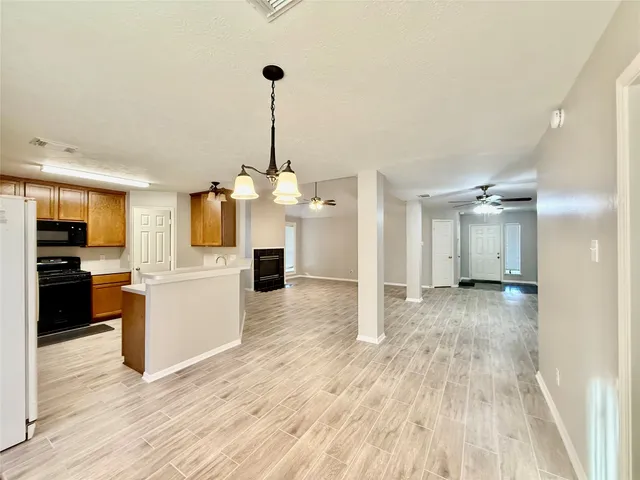 a view of a kitchen center island wooden floor and stainless steel appliances