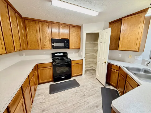 a kitchen with granite countertop wooden cabinets and stainless steel appliances