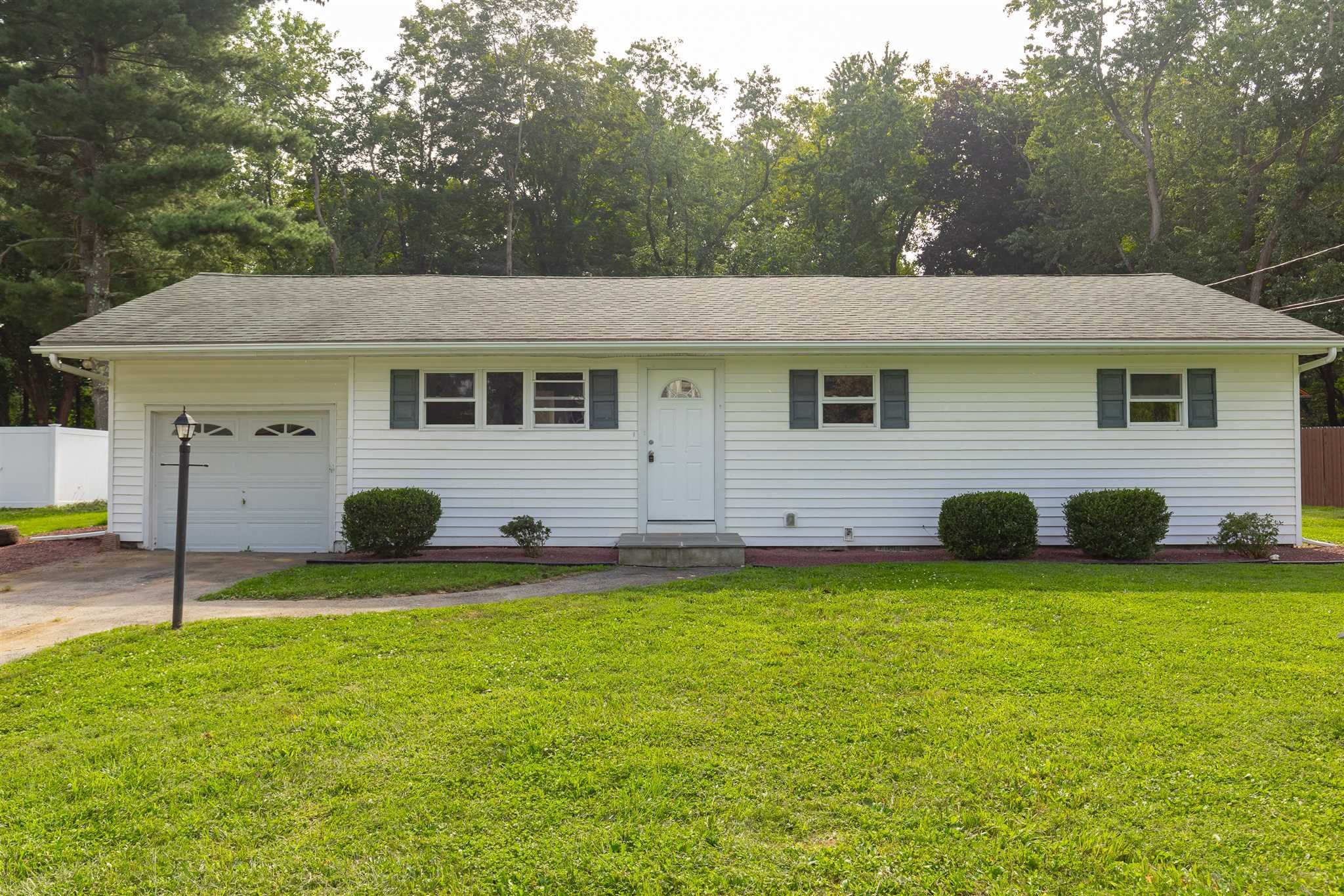 a view of a house with a backyard and a tree