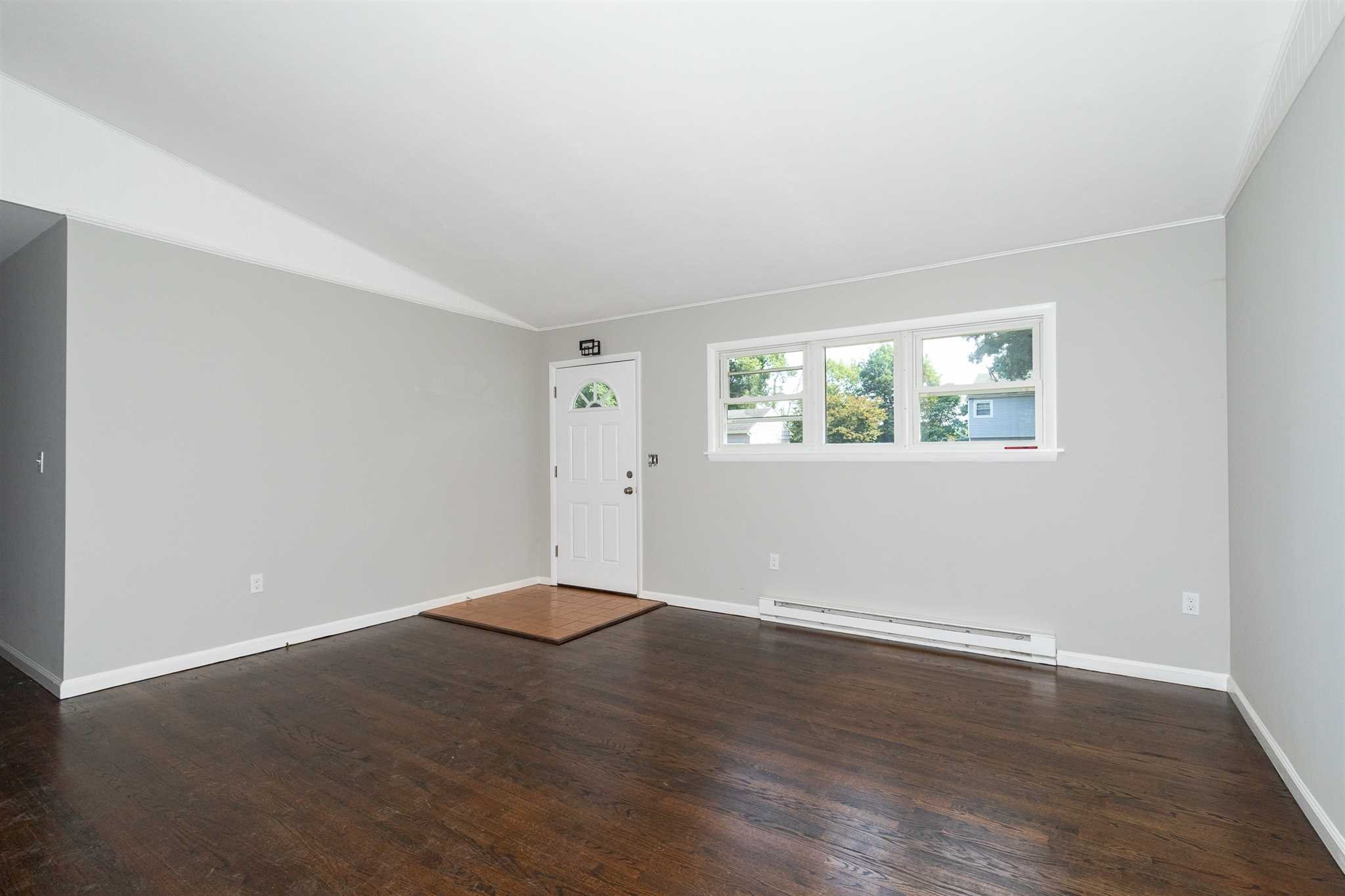 29 Milano Drive LaGrange, NY 12603 - Photo 4 of 21 an empty room with wooden floor and windows
