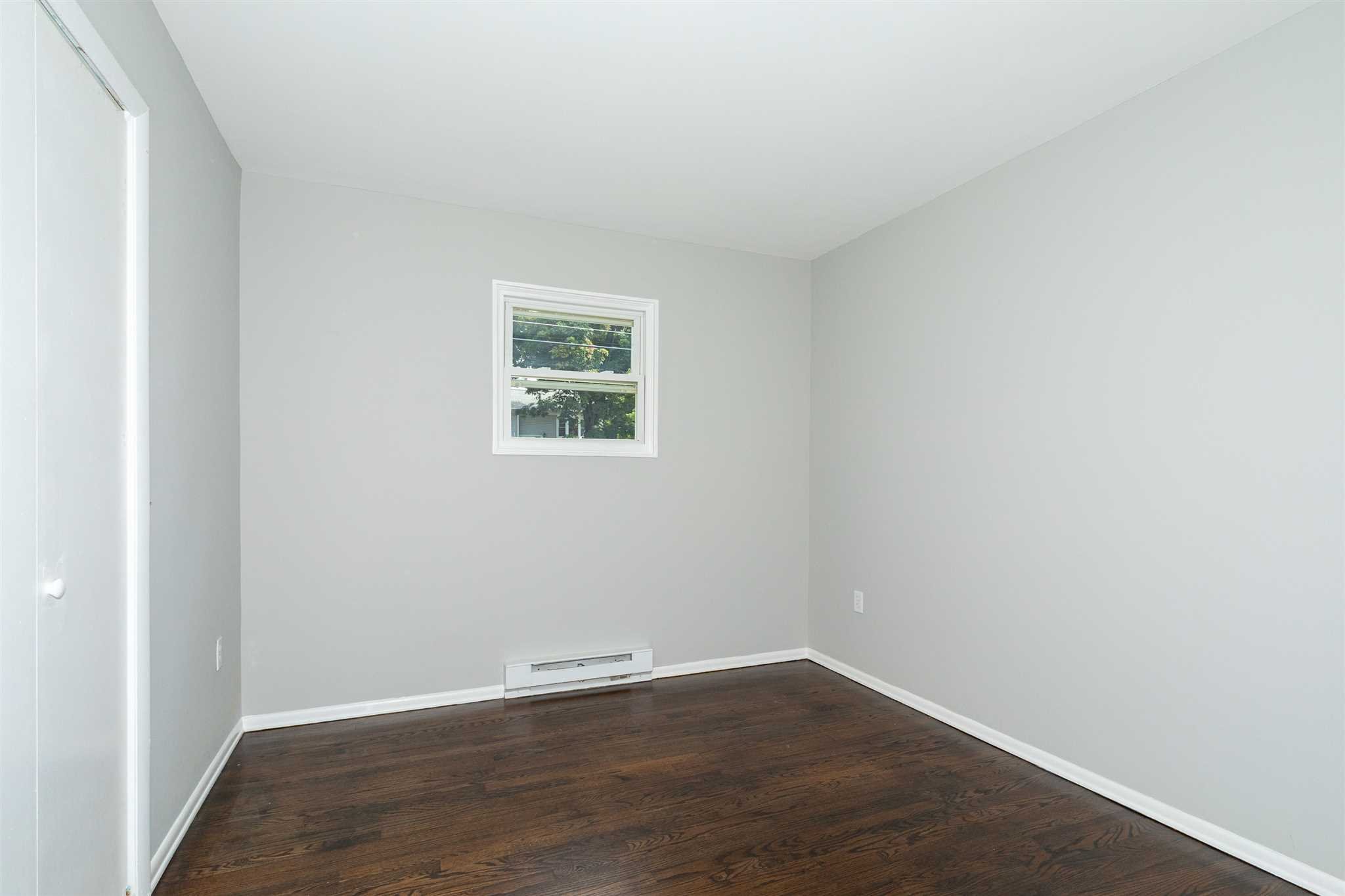 29 Milano Drive LaGrange, NY 12603 - Photo 10 of 21 an empty room with wooden floor and windows