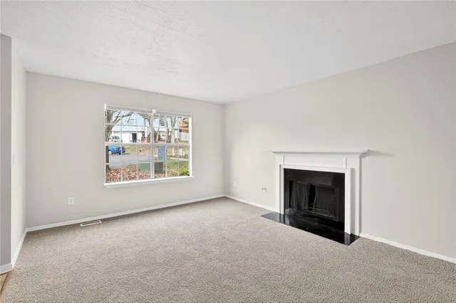 an empty room with furniture and a fireplace