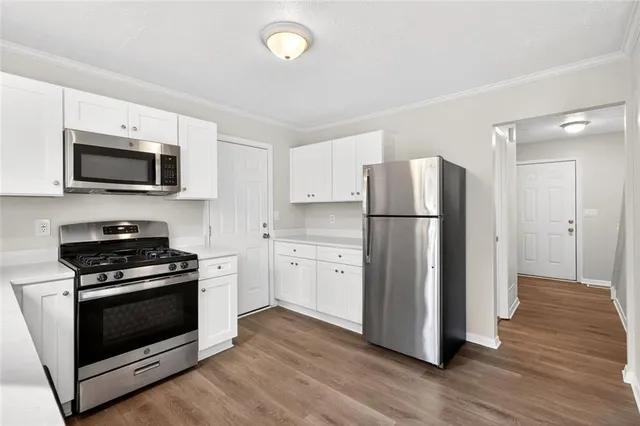 a kitchen with a refrigerator stove and wooden cabinets
