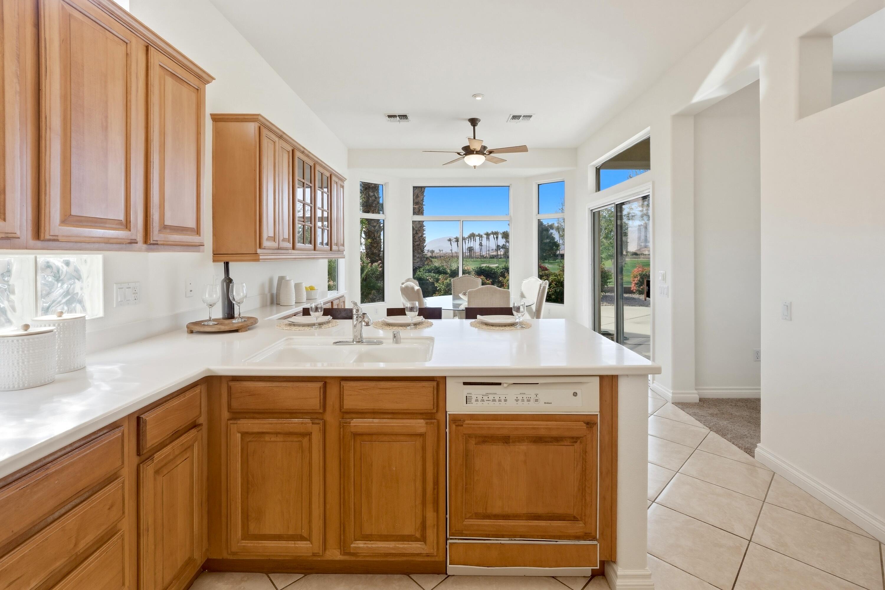 35440 Moorbrook Road Palm Desert, CA 92211 - Photo 17 of 32 a kitchen with kitchen island granite countertop a sink and cabinets
