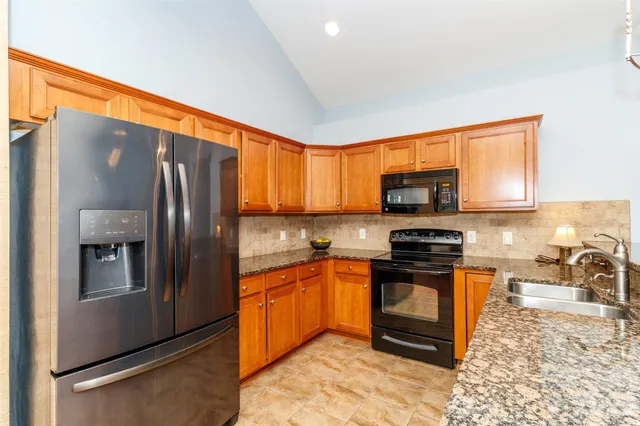a kitchen with stainless steel appliances granite countertop a refrigerator stove microwave and sink
