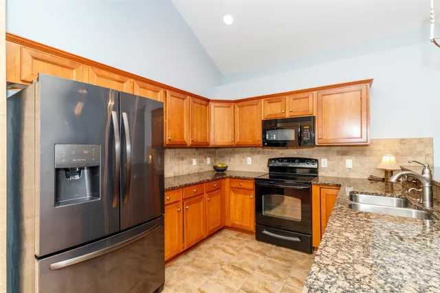 a kitchen with stainless steel appliances granite countertop a refrigerator stove and sink