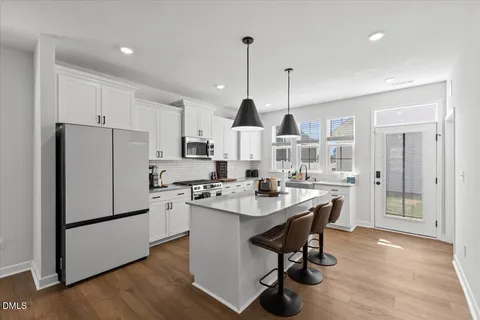 a kitchen with stainless steel appliances kitchen island a sink a stove and a refrigerator