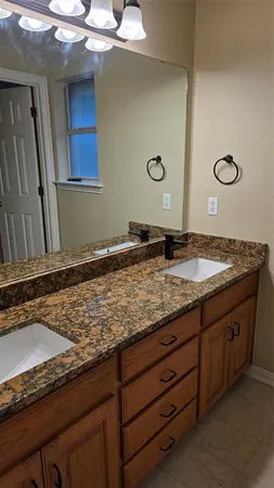 a bathroom with a granite countertop sink and a mirror