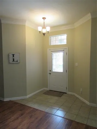 an empty room with wooden floor sink and window