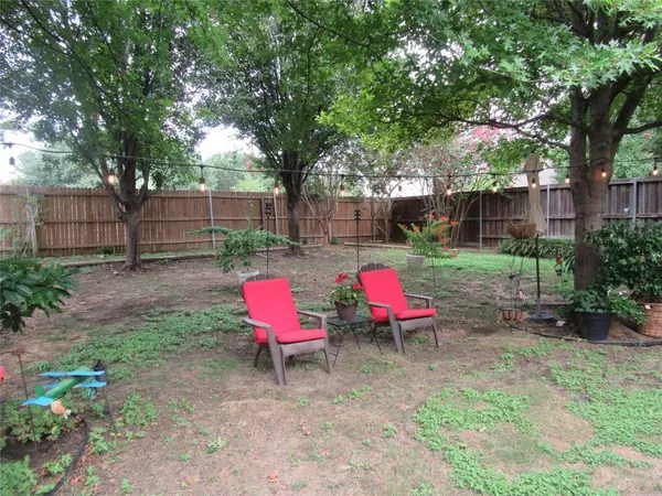a view of a backyard with sitting area and wooden fence