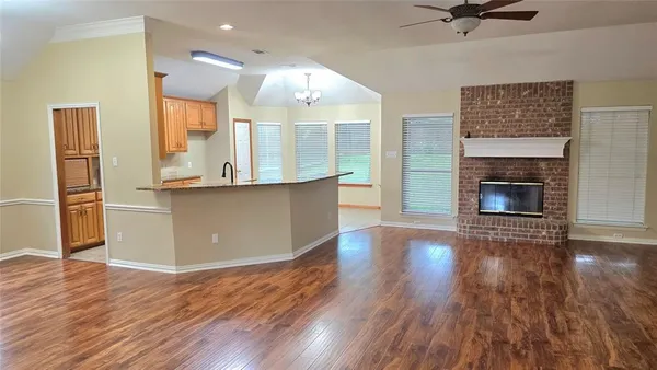 an open kitchen with wooden floor and a fireplace