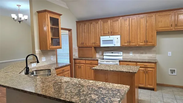 a kitchen with stainless steel appliances granite countertop a stove top oven a sink and dishwasher