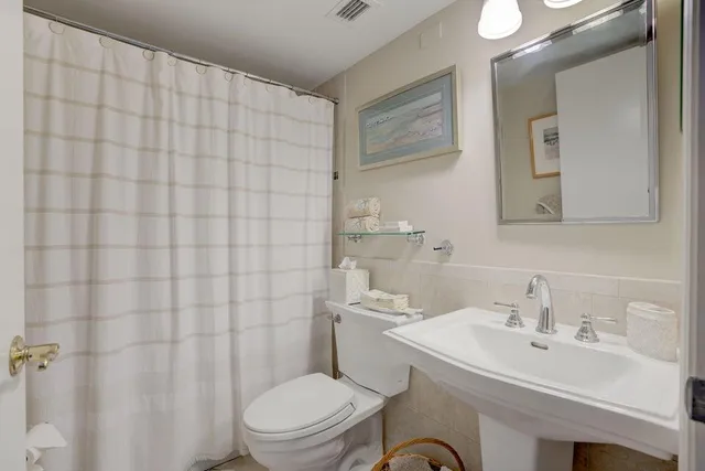 a bathroom with a sink a toilet and shower curtain