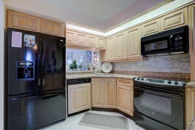 a kitchen with stainless steel appliances granite countertop a stove microwave and refrigerator