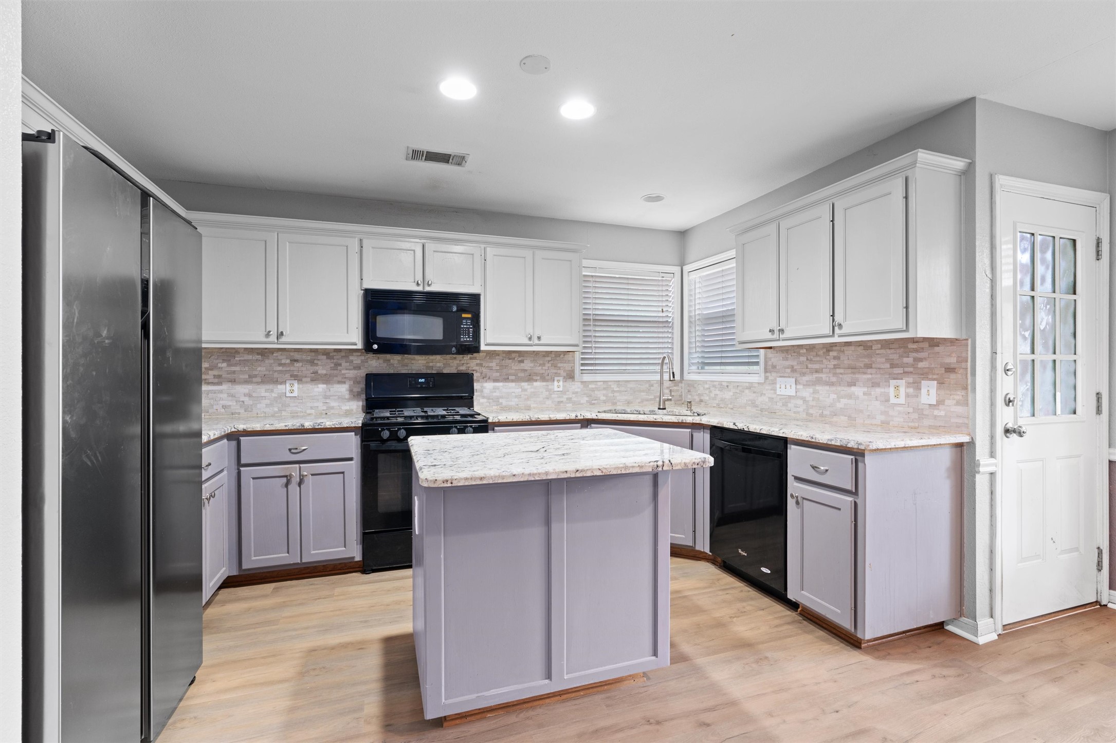 2306 Raintree Path Round Rock, TX 78664 - Photo 8 of 23 A well-lit kitchen with modern appliances and an inviting central island awaits culinary adventures.