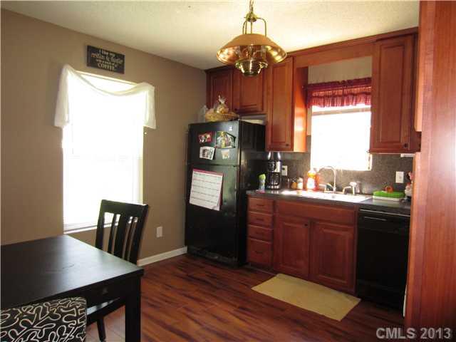 20116 Walter Henderson Road Cornelius, NC 28031 - Photo 4 of 15 a kitchen with stainless steel appliances granite countertop a refrigerator a stove a sink dishwasher and a dining table with wooden floor