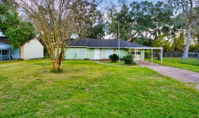 a view of a house with a yard and tree