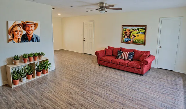 a living room with wooden floor furniture and a potted plant