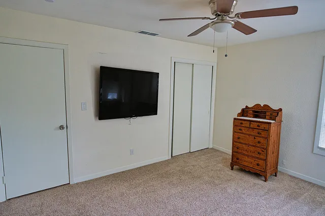 a view of room with flat screen tv and fan