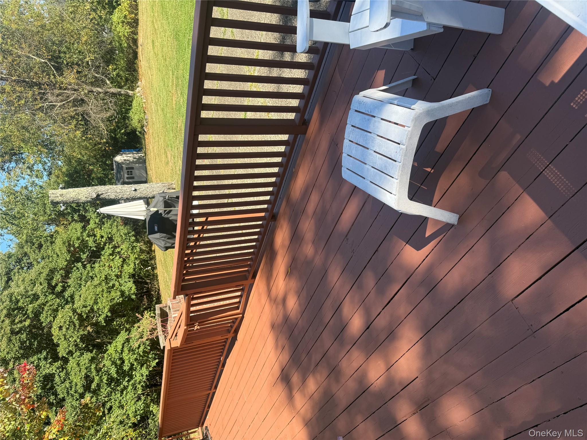 18 Adams Road Ossining, NY 10562 - Photo 20 of 41 Wooden deck with a storage unit, a yard, and view of scattered trees