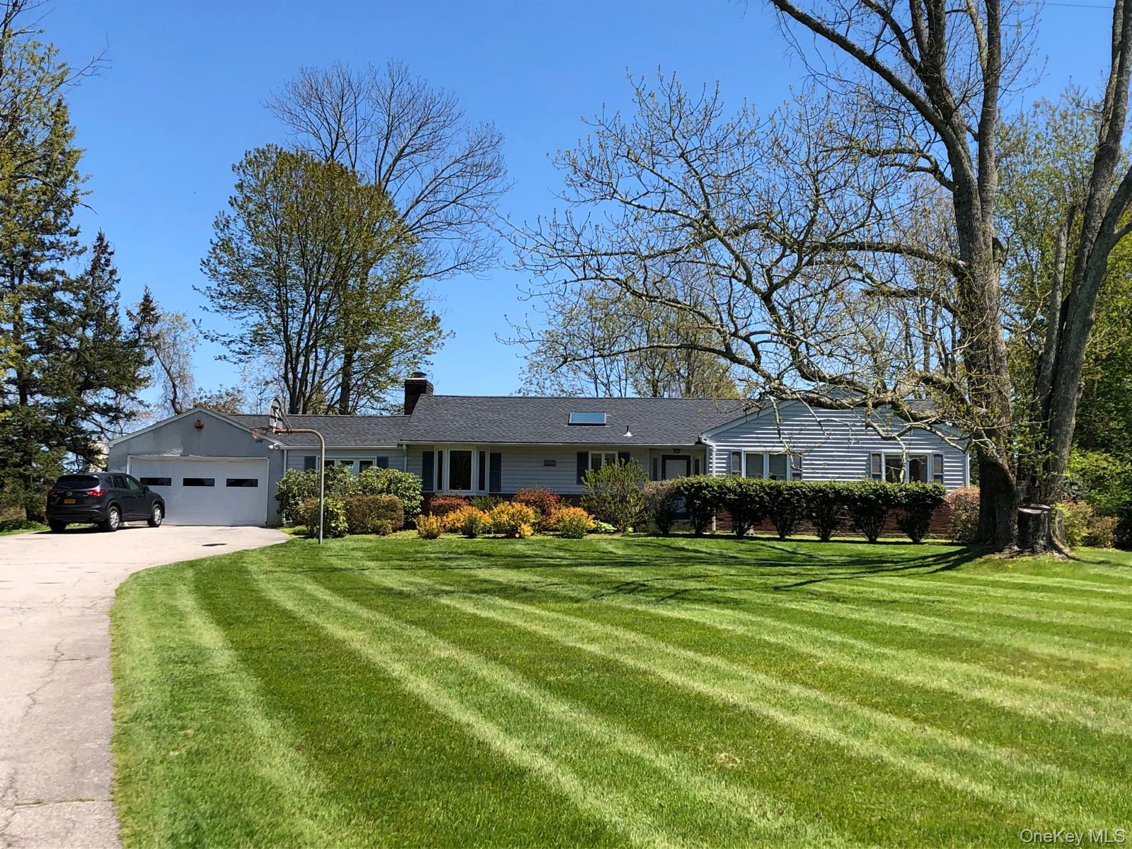 18 Adams Road Ossining, NY 10562 - Photo 2 of 41 Ranch-style house with a front lawn, driveway, a chimney, and an attached garage