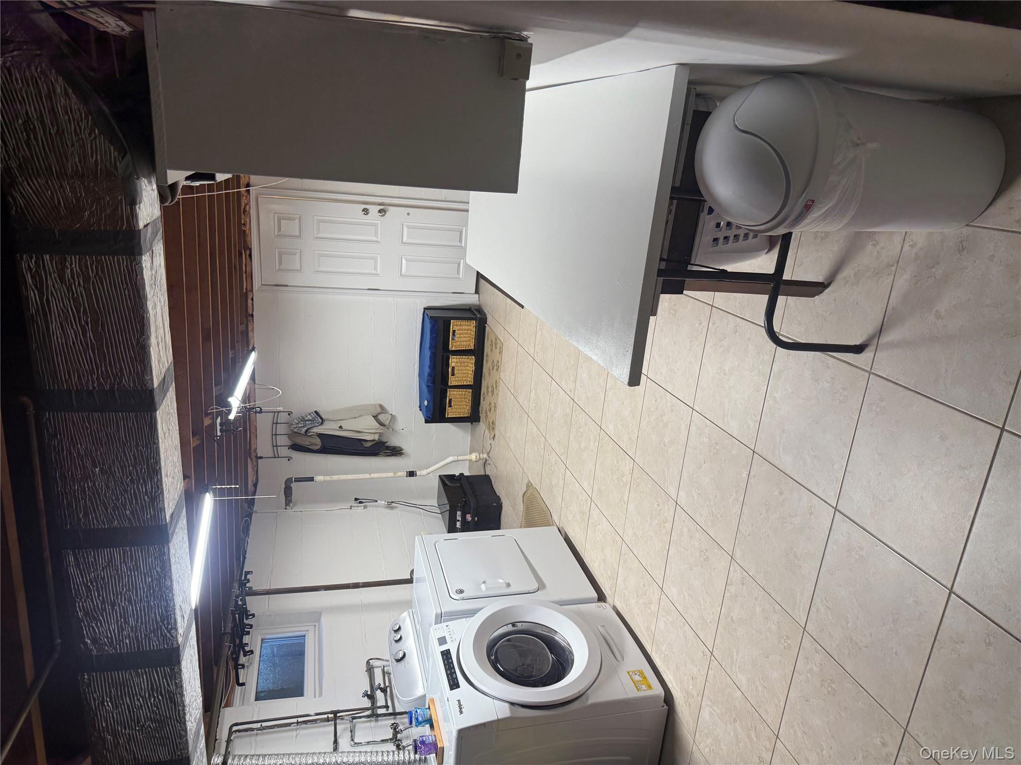 18 Adams Road Ossining, NY 10562 - Photo 28 of 41 Laundry room featuring separate washer and dryer and light tile patterned flooring