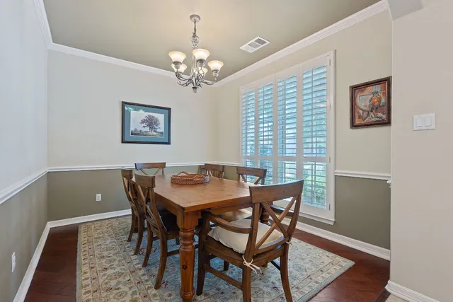 a view of a dining room with furniture a chandelier and wooden floor