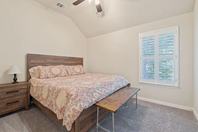 a bedroom with a bed dresser and a window