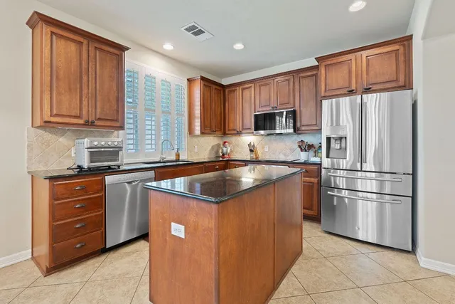 a kitchen with stainless steel appliances granite countertop a refrigerator sink and cabinets