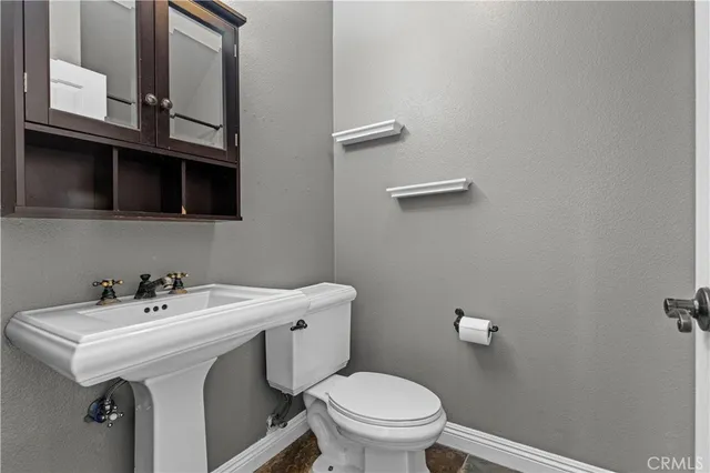 a bathroom with a sink a toilet and mirror