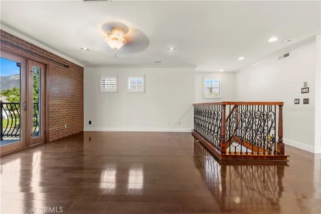 a view of a hallway with wooden floor and windows