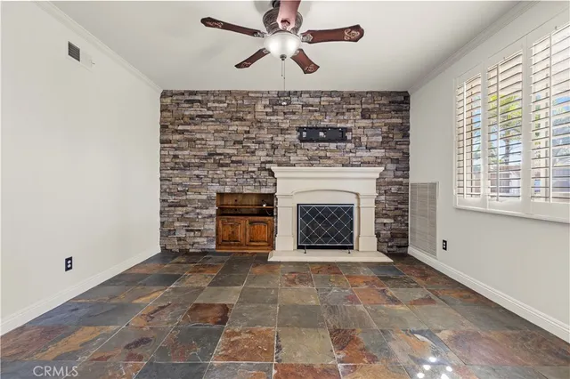 a view of an empty room with a fireplace and a window