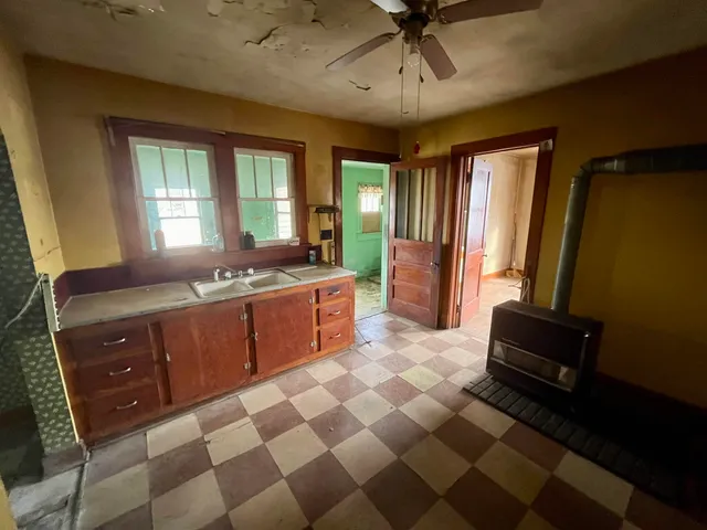a room with a black white checkered floor with couches and chandelier
