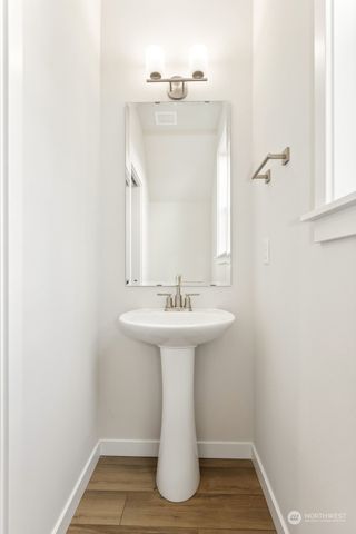 a kitchen with stainless steel appliances granite countertop a stove a sink and a refrigerator with wooden floors