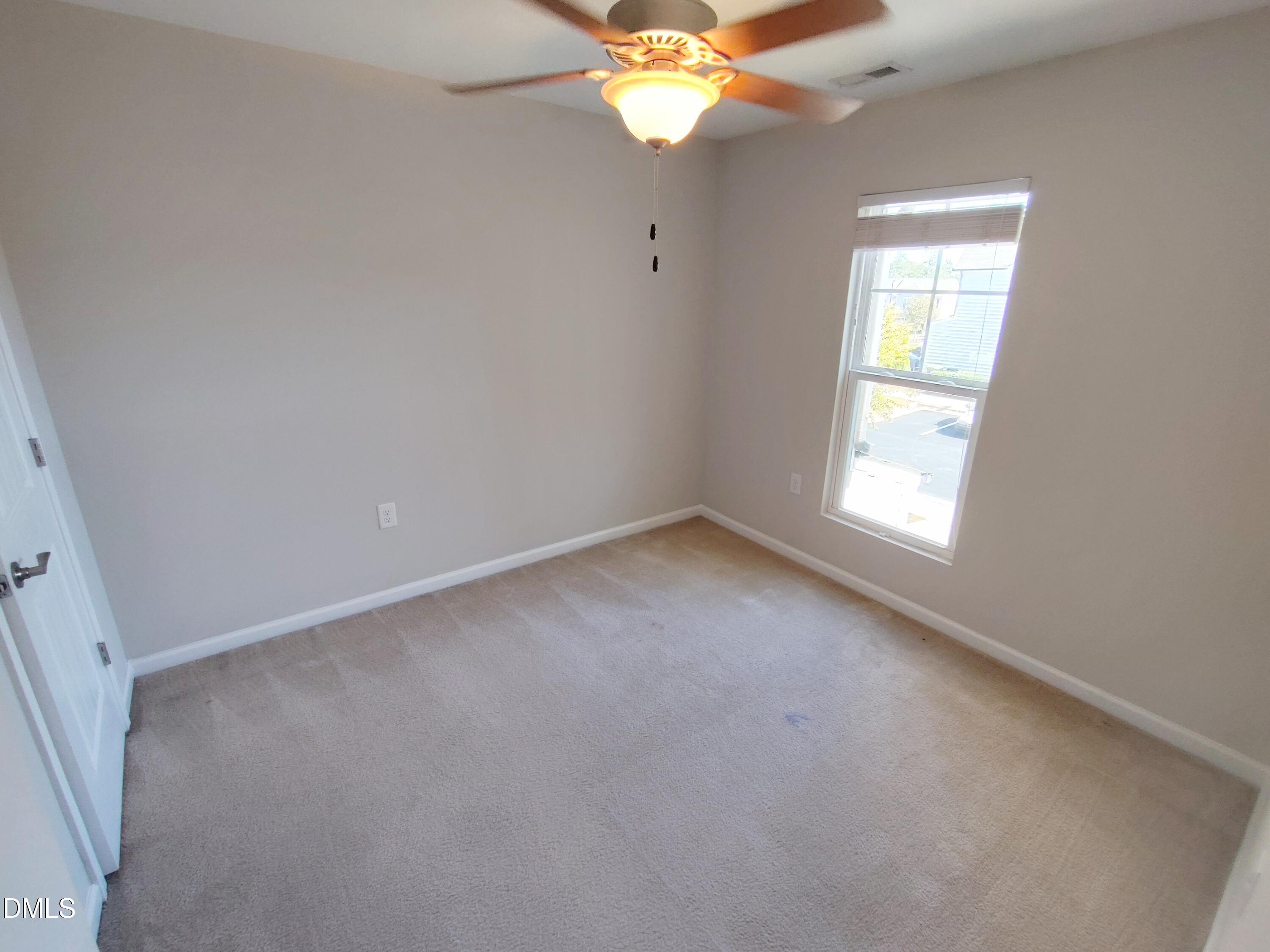 1013 Kudzu Street Durham, NC 27713 - Photo 13 of 21 an empty room with a chandelier fan and windows