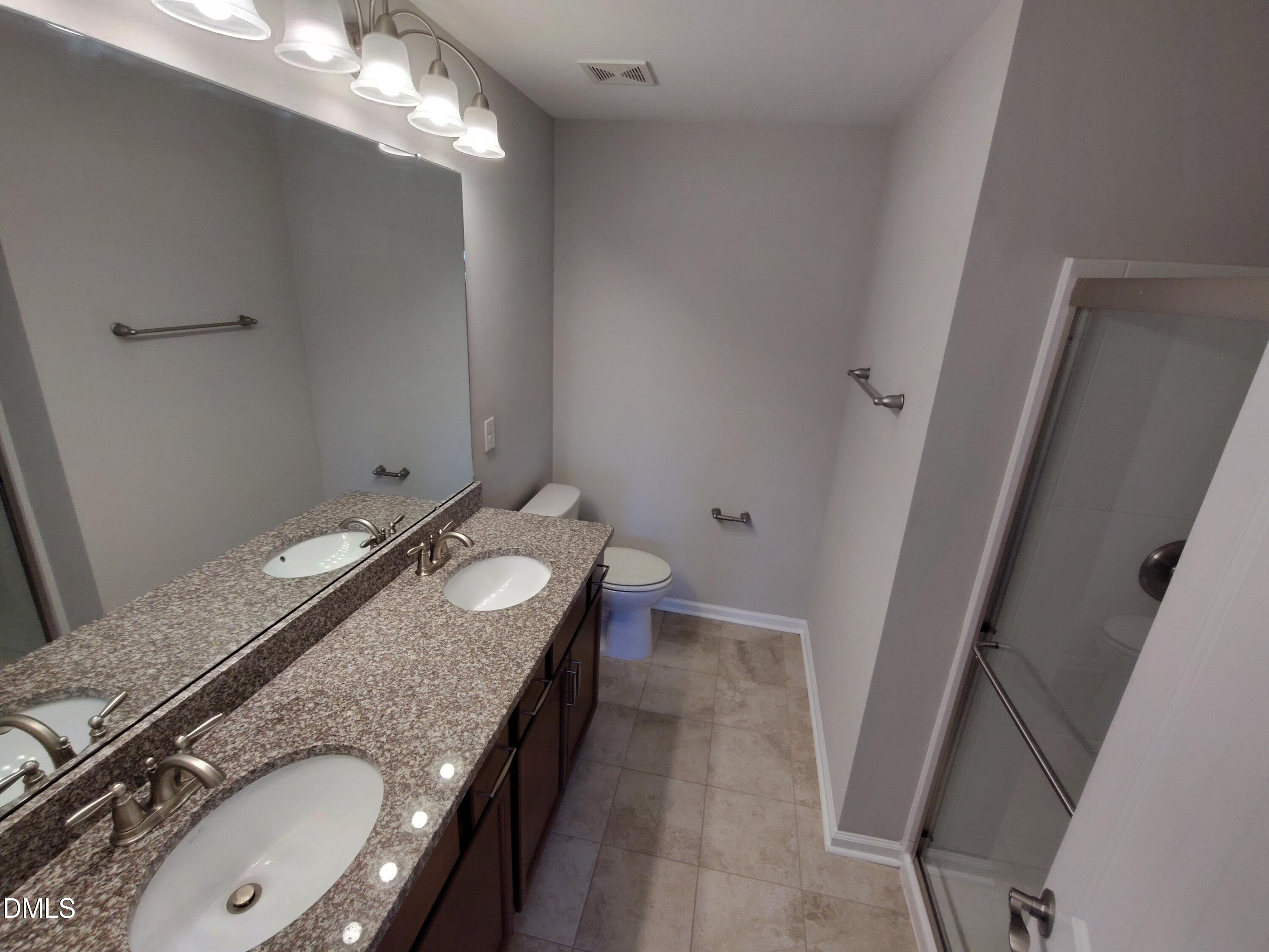 1013 Kudzu Street Durham, NC 27713 - Photo 18 of 21 a bathroom with a granite countertop double vanity sink and mirror with window
