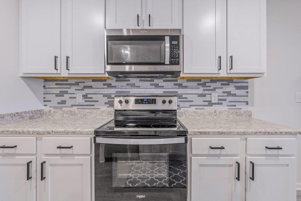 510 Earl Godwin Road Freeport, FL 32439 - Photo 20 of 42 a kitchen with granite countertop a stove sink and microwave
