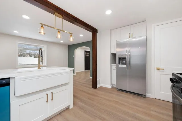 a kitchen with kitchen island a refrigerator and a sink
