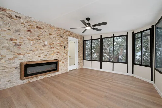a view of empty room with wooden floor and fireplace