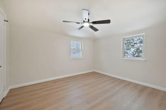 a view of empty room with wooden floor