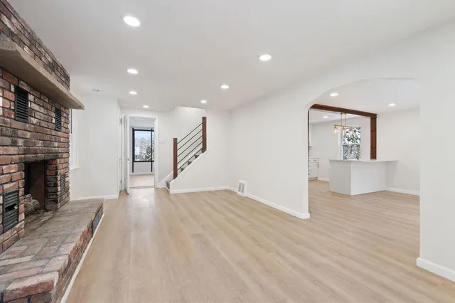 a view of a kitchen with wooden floor and a fireplace