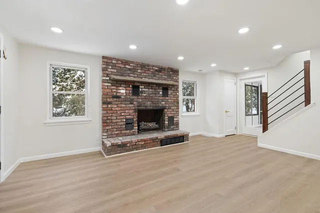 a view of an empty room with a fireplace and a window