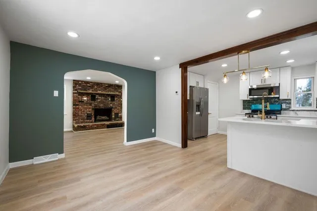 a view of kitchen with kitchen island wooden floor center island and stainless steel appliances