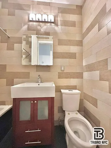a bathroom with a toilet sink and mirror