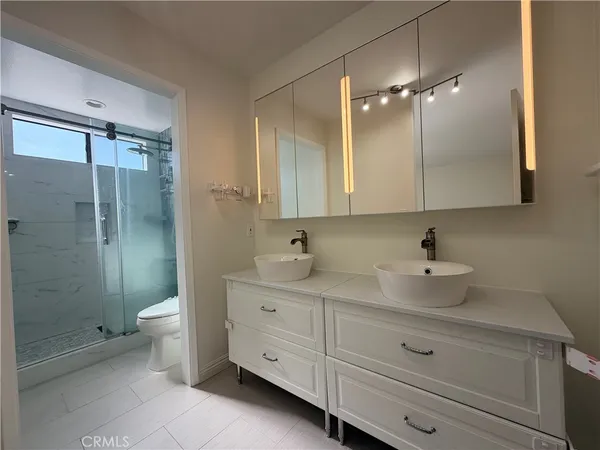 a bathroom with a double vanity sink toilet and shower