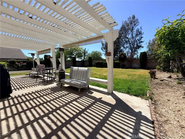 a view of a patio with table and chairs potted plants and palm trees