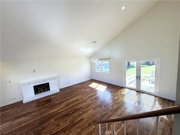 a view of empty room with wooden floor and fireplace