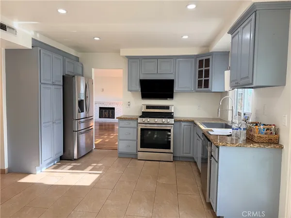 a kitchen with a refrigerator sink and stove top oven