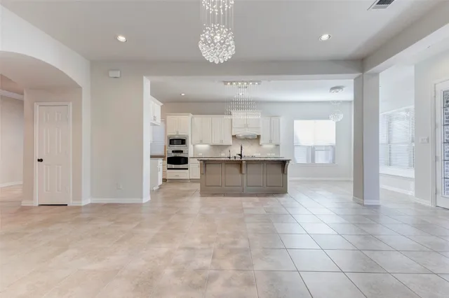 a view of kitchen with granite countertop cabinets and refrigerator