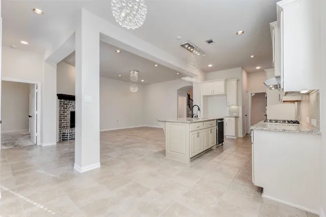 a large white kitchen with kitchen island a sink a stove and a refrigerator